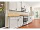 Well-equipped kitchen with stainless steel range, white cabinets, and a view to the outdoor space at 1037 Panoramic Pte, Buford, GA 30518