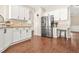Modern kitchen with stainless steel refrigerator and white cabinets with light countertops. The floor is hardwood at 1037 Panoramic Pte, Buford, GA 30518