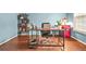 Bright home office with wood floors, a large desk, and shelving with various sport-themed items at 1037 Panoramic Pte, Buford, GA 30518