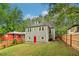 Backyard view of two-story home with red door and fenced-in yard at 1393 Westview Sw Dr, Atlanta, GA 30310
