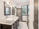 Bathroom featuring double sinks, dark cabinets, and access to modern bath and shower at 1393 Westview Sw Dr, Atlanta, GA 30310