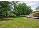 Large backyard with a deck featuring outdoor seating, mature trees and lush green grass at 3060 Wilson Rd, Decatur, GA 30033