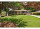 Charming single-story brick home featuring blue shutters and a well-manicured lawn and mature trees at 3060 Wilson Rd, Decatur, GA 30033