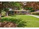 Charming brick home with a well-manicured lawn, blue shutters, and mature trees for shade at 3060 Wilson Rd, Decatur, GA 30033