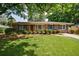 Charming brick home with a well-manicured lawn, mature trees, and blue shutters at 3060 Wilson Rd, Decatur, GA 30033