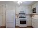 Cozy kitchen with white cabinetry, tile floor, and stainless steel refrigerator at 3060 Wilson Rd, Decatur, GA 30033