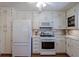 Charming kitchen featuring white cabinets, modern appliances, and tiled flooring at 3060 Wilson Rd, Decatur, GA 30033