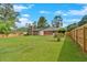 Large fenced backyard with manicured lawn, a wooden deck, and mature landscaping at 4129 Pepperdine Dr, Decatur, GA 30034