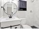 Modern bathroom features a stylish vanity with a round mirror, tiled walk-in shower, and sleek finishes at 4129 Pepperdine Dr, Decatur, GA 30034