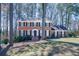 The front exterior features a classic brick facade, complemented by a well-manicured lawn and beautiful, mature trees at 725 Glengary Ne Way, Atlanta, GA 30342