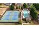 Aerial view of backyard featuring a tennis court, a swimming pool, and mature trees at 1025 Saint Marks Walk, Suwanee, GA 30024