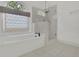Relaxing bathroom with soaking tub, glass shower, and a large arched window at 1025 Saint Marks Walk, Suwanee, GA 30024