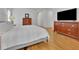 Inviting bedroom featuring hardwood floors and a large dresser with a television at 1025 Saint Marks Walk, Suwanee, GA 30024