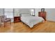 Light bedroom showcasing a plush queen bed, wooden floors, and bright natural light at 1025 Saint Marks Walk, Suwanee, GA 30024