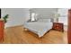 Spacious bedroom with a large bed, wooden nightstands, and wood flooring at 1025 Saint Marks Walk, Suwanee, GA 30024