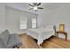 Bright bedroom features wood floors, a ceiling fan, a gray futon and two windows at 1025 Saint Marks Walk, Suwanee, GA 30024