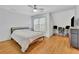 This bedroom features hardwood floors, a ceiling fan, a window, and a comfortable bed at 1025 Saint Marks Walk, Suwanee, GA 30024