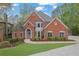 Charming brick home featuring lush landscaping, a well-manicured lawn, and a welcoming entrance at 1025 Saint Marks Walk, Suwanee, GA 30024