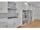 Modern kitchen featuring white cabinets, granite countertops, stainless steel appliances, and a gas cooktop at 1025 Saint Marks Walk, Suwanee, GA 30024