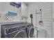 Well-organized laundry room with a front-load washer and dryer, ample shelving, and shiplap paneling at 1025 Saint Marks Walk, Suwanee, GA 30024