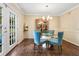 Dining room boasts a round glass table, four chairs, dark wood floors and lovely french doors to outdoor space at 3147 Buford Ne Hwy # 2, Atlanta, GA 30329