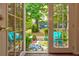 A picturesque outdoor view of a patio with seating and lush greenery through a glass french door at 3147 Buford Ne Hwy # 2, Atlanta, GA 30329