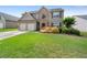 Traditional home featuring stone accents, manicured lawn, and attached two-car garage at 3235 Northcliff Dr, Suwanee, GA 30024