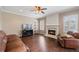 This beautiful living room features a cozy fireplace, hardwood floors, and a large window with plantation shutters at 3235 Northcliff Dr, Suwanee, GA 30024