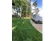 View of grassy backyard with mature trees and a concrete path at 5567 Stapleton Dr, Dunwoody, GA 30338