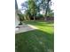 View of grassy backyard with mature trees and a concrete path at 5567 Stapleton Dr, Dunwoody, GA 30338