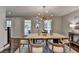 Sunlit dining room with hardwood floors, wood table, decorative rug, and modern chandelier at 5567 Stapleton Dr, Dunwoody, GA 30338