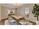 Dining room features modern light fixture, wood table, and doorway to kitchen at 5567 Stapleton Dr, Dunwoody, GA 30338