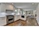 Gourmet kitchen with stainless steel appliances, white cabinets, hardwood floors, and open floor plan at 5567 Stapleton Dr, Dunwoody, GA 30338