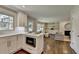Open-concept kitchen with white cabinets, stainless steel appliances, and seamless flow to the living area at 5567 Stapleton Dr, Dunwoody, GA 30338