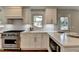 Modern kitchen featuring stainless steel appliances, quartz countertops, and white cabinets with gold hardware at 5567 Stapleton Dr, Dunwoody, GA 30338