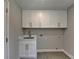 Well-lit laundry room with white cabinets, stainless steel sink, and modern fixtures at 5567 Stapleton Dr, Dunwoody, GA 30338
