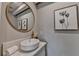 Stylish powder room featuring marble countertop and decorative mirror at 5567 Stapleton Dr, Dunwoody, GA 30338