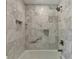 Detailed view of the shower with marble tiling and bronze shower head at 5567 Stapleton Dr, Dunwoody, GA 30338