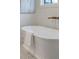 Bright bathroom featuring a luxurious soaking tub with gold fixtures and stylish hexagon tile flooring at 56 Pine St, Roswell, GA 30075
