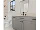 Gray bathroom cabinet with white counter, black faucet, and tiled shower at 56 Pine St, Roswell, GA 30075