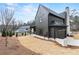 A dark, modern house with a well-manicured lawn and a three-car garage at 56 Pine St, Roswell, GA 30075