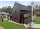 A modern home exterior showcasing a dark siding, black trim, and a well-manicured lawn at 56 Pine St, Roswell, GA 30075