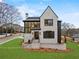 Stunning two-story home featuring a modern black-and-white facade and manicured landscaping at 56 Pine St, Roswell, GA 30075