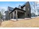 A modern house boasts a covered porch, dark siding and freshly seeded lawn at 56 Pine St, Roswell, GA 30075