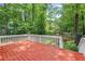 View of a wooden back deck overlooking a wooded backyard with play equipment at 959 Vendue Dr, Lawrenceville, GA 30044