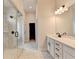 Open bathroom space featuring glass shower, dual sink vanity, and marble-patterned tile flooring at 1620 Branthaven Ln, Auburn, GA 30011