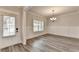 Dining room with wainscoting, neutral paint, hardwood floors, and modern chandelier lighting at 1620 Branthaven Ln, Auburn, GA 30011