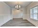 Bright dining room with wood floors, modern lighting, wainscoting details, and a sunlit window at 1620 Branthaven Ln, Auburn, GA 30011