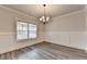 Inviting dining area with hardwood floors, window, wainscoting, and chandelier lighting at 1620 Branthaven Ln, Auburn, GA 30011