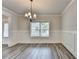 Stylish dining room featuring hardwood floors, wainscoting, and a chandelier above a window at 1620 Branthaven Ln, Auburn, GA 30011